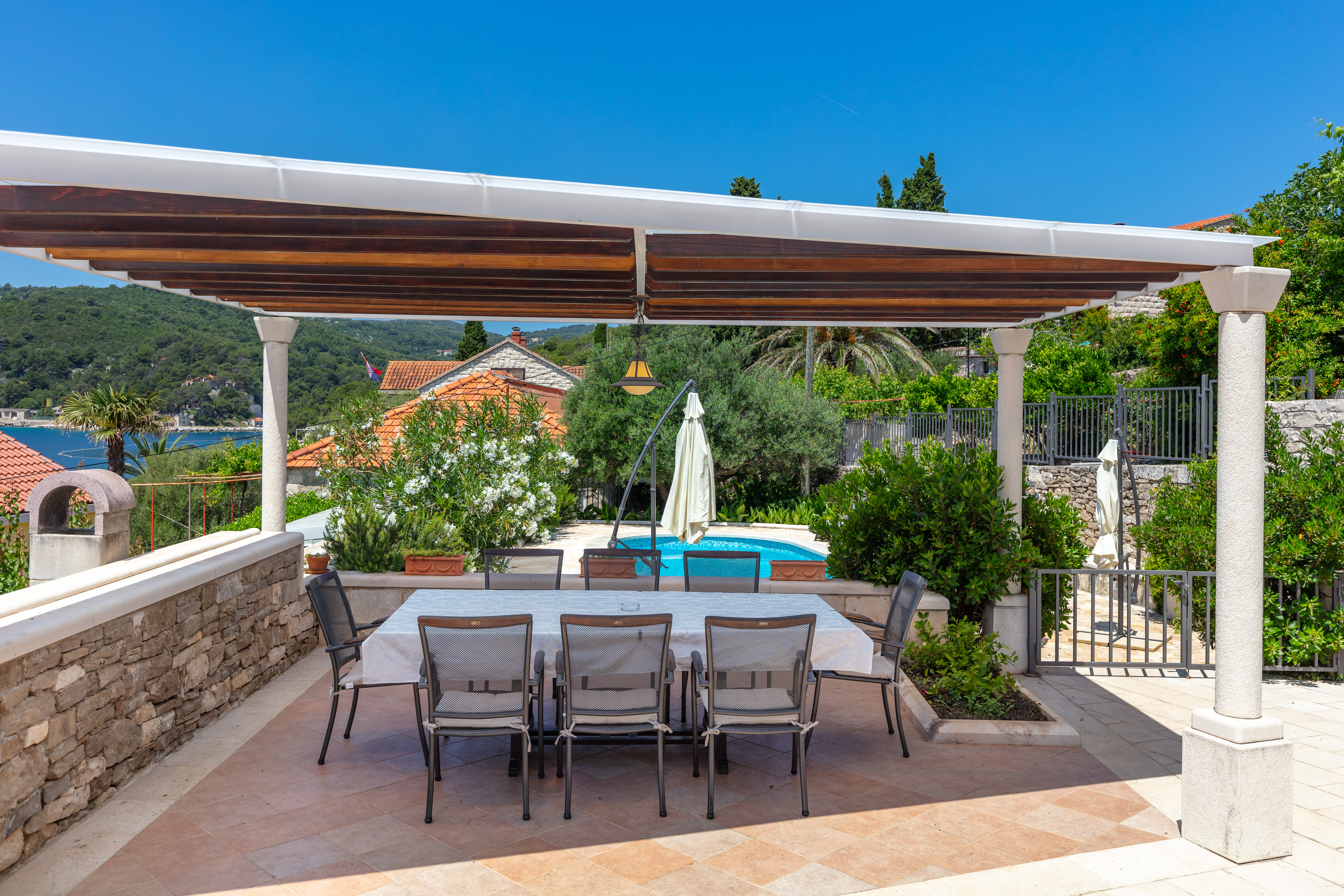 Covered outside dining area with swimming pool view
